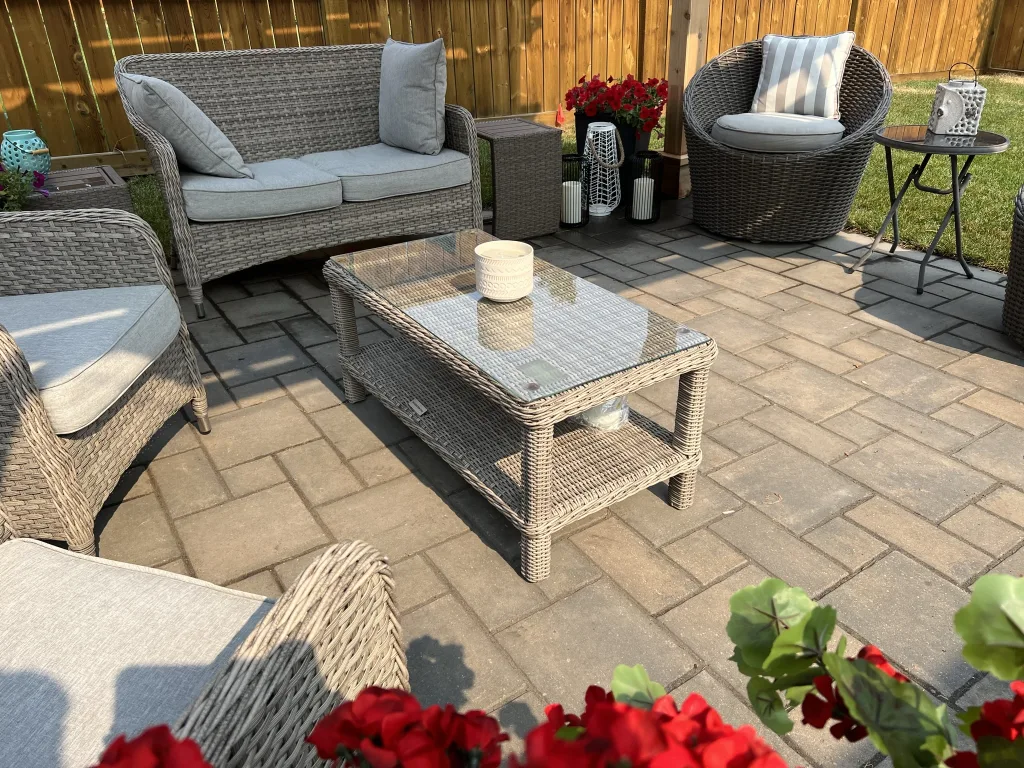 Verano sierra grey paver stone patio with wicker furniture and red flowers